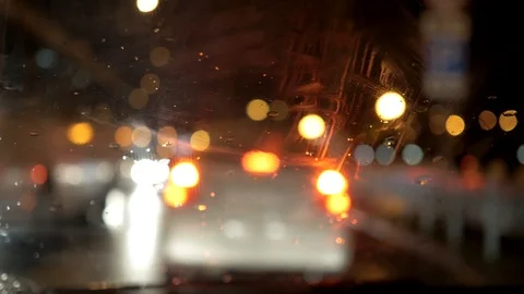 Raindrops fall on the windshield of car, bokeh in the background Stock Footage 105207492