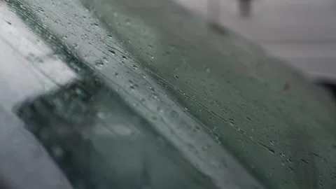 Raindrops fall on the windshield of a car. Видео 331933361