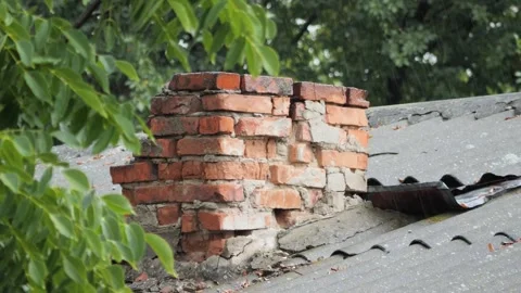 Raindrops falling on an aged brick chimney and slate rooftop in a village. Video stock 342801590