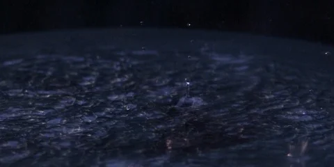Raindrops falling and splashing into the puddle Stock Footage 103748284