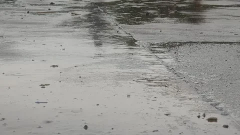 Raindrops falling on asphalt or concrete road surfaces Stock Footage 327193174