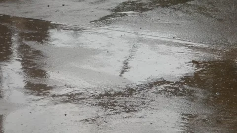 Raindrops falling on asphalt or concrete road surfaces Stock Footage 327193213