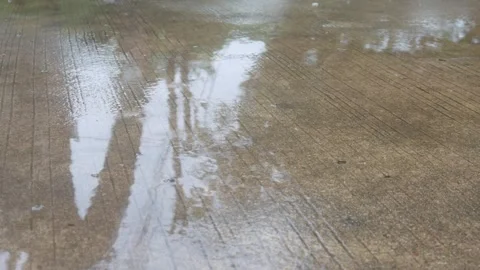 Raindrops falling on asphalt or concrete road surfaces Stock Footage 327193219