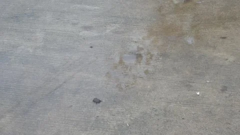 Raindrops falling on asphalt or concrete road surfaces Stock Footage 327193269