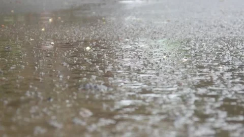 Raindrops falling on asphalt or concrete road surfaces Stock Footage 327193413