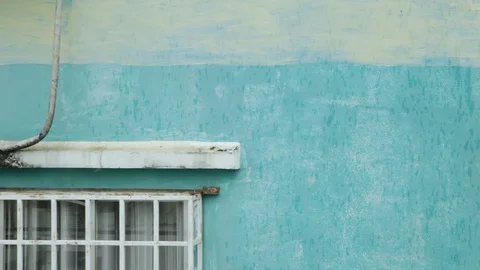 Raindrops falling on a blue building wall and leaving traces Stock Footage 129772408