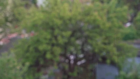 Raindrops falling on blurred background of houses Stock Footage 129815996