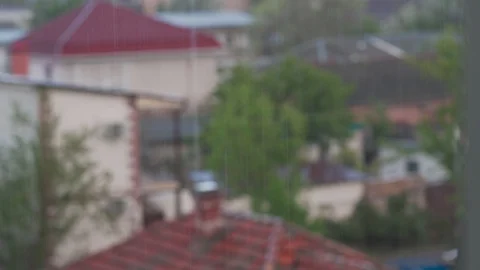 Raindrops falling on a blurry background of roofs Vidéo 129815629