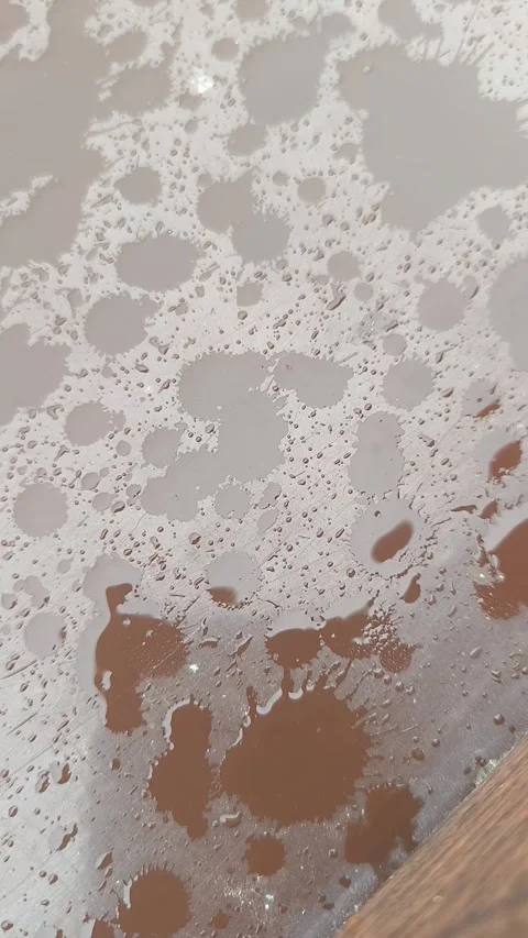 Raindrops Falling on Brown Surface with Ripples and Reflections | Close-Up Water Video stock 317233741