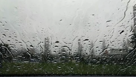 Raindrops falling on car windshield with traffic passing by Stock Footage 166949533