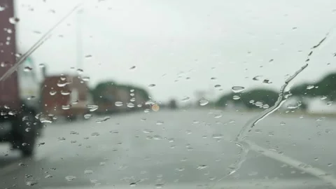 Raindrops falling on the car windshield, Windshield wipers cleaning water dro Stockbeeldmateriaal 156954547