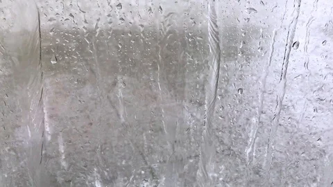 Raindrops falling in city on window Stock Footage 120138087