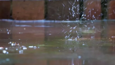 Raindrops falling on concrete with terracotta bricks wall Stock Footage 136986287