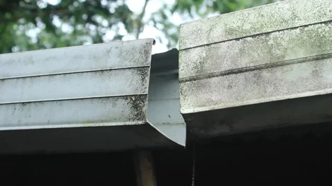 Raindrops falling down from box-shaped gutters facing each other. Video stock 274938455