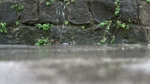 Raindrops falling during a thunderstorm against a stone wall Stock-Footage 42311794