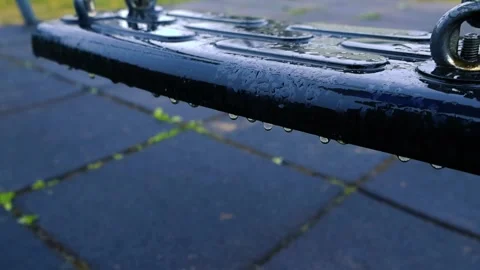 Raindrops Falling on an Empty Playground Swing Seat Close Up Stock Footage 335132452