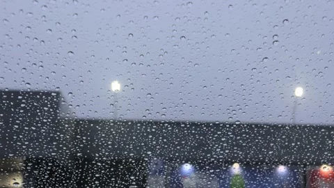 Raindrops Falling On Glass Window Overlooking Blurred Urban City Street Lights Stock Footage 329579537