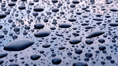 Raindrops falling on a gray plate reflected on the sky and clouds. Stock Footage 153853289