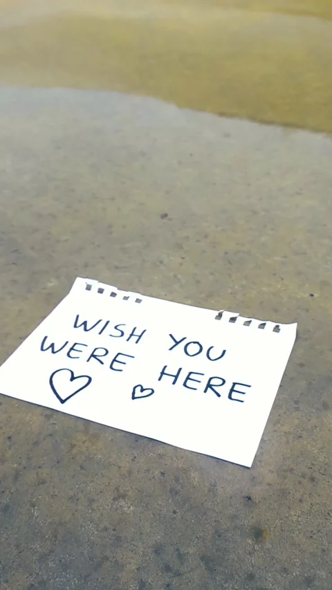 Raindrops Falling on a Handwritten Love Note with the Message Wish You Were Here Stock Footage 335634799