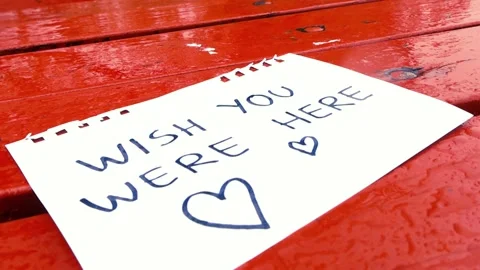 Raindrops Falling on a Handwritten Love Note on Park Table Stock Footage 336650934