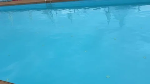Raindrops falling on an outdoor swimming pool surface Stock Footage 318283629