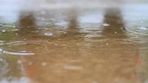Raindrops falling into a puddle in slow motion. Stock Footage 120125076