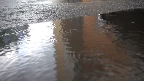 Raindrops falling into a puddle in slow motion Stock Footage 144046891