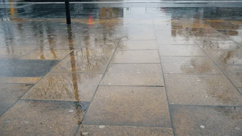 Raindrops of falling on puddles on a sidewalk and road. Rainy day. 스톡 동영상 87961428