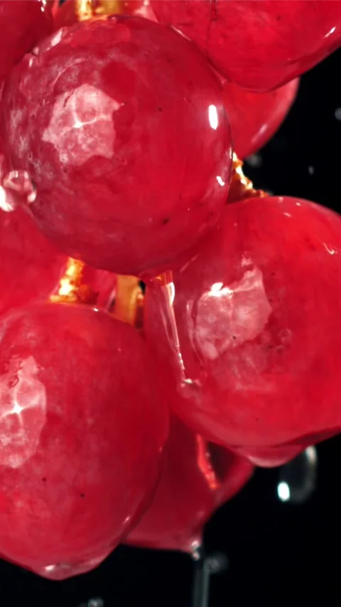 Raindrops falling on red grapes on black background. Filmed on a high-speed Stock Footage 335320069