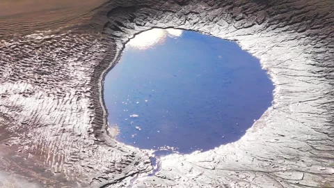 Raindrops Falling on a Reflective Muddy Pool with Clouds in Tambopata, Aerial Stock Footage 314320363
