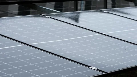 Raindrops falling on solar panels producing renewable energy Stock Footage 345437469