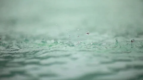 Raindrops falling on the surface of a pool, close up Stock Footage 100306948