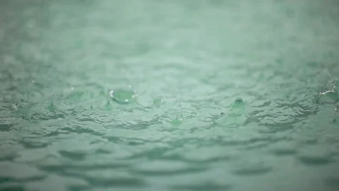 Raindrops falling on the surface of a pool, close up Video stock 100306949
