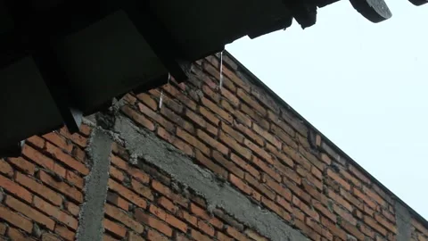 Raindrops falling from the tiles of a house with a brick wall Stock Footage 297168237