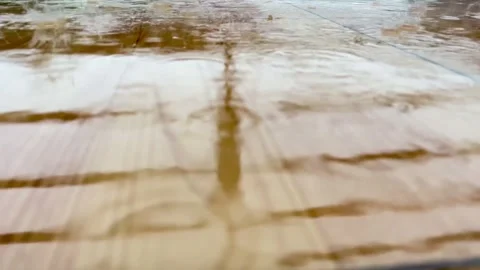 Raindrops falling on a wet tiled floor with soft reflections and ripples Stock Footage 340777343