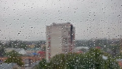 Raindrops falling on the window with blurred urban landscape on the background Stock Footage 133137519