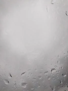 Raindrops falling on window glass surface Stock Photos