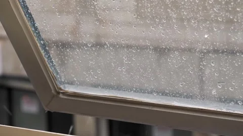 Raindrops falling on a window pane during a heavy rainstorm Stock Footage 331780915