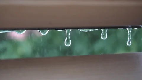Raindrops falling on the window on a rainy and windy day close up in slow motion Stock Footage 101030028