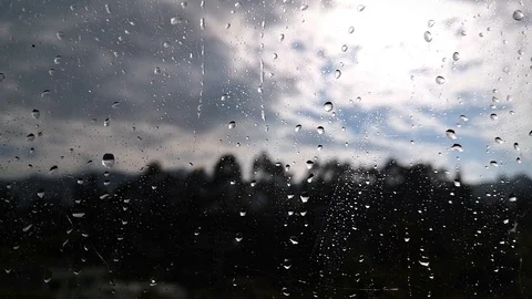 Raindrops falling on a window with an unfocused background of a mountain Video stock 127186063