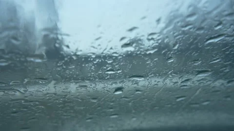 Raindrops falling on the windshield of the car Vídeos de archivo 327543203