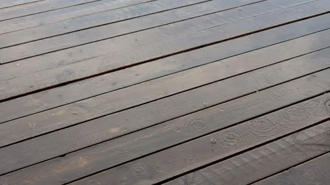 Raindrops falling on a wooden deck floor Stock Footage 338384662
