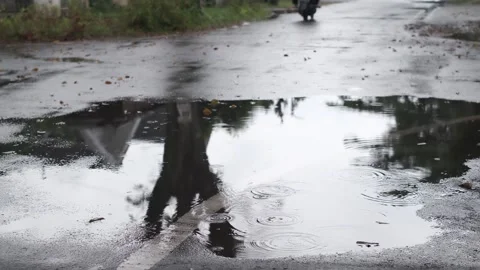 Raindrops fell in the puddles on the side of the road Stock Footage 241338318
