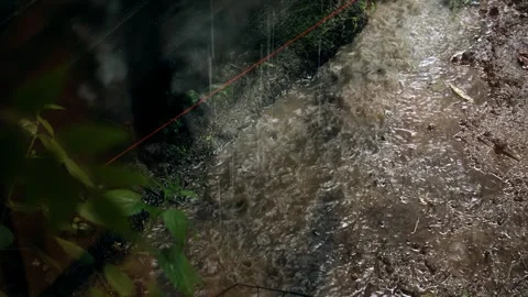 Raindrops fill a puddle outside the window where there is a heavy downpour Stock Footage 315791500