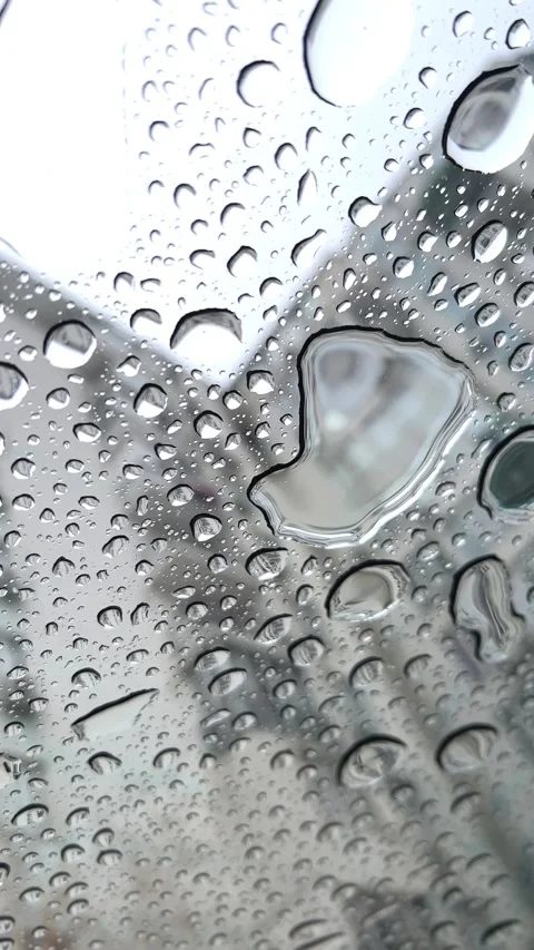 Raindrops flow down the glass ceiling of a car window Video stock 304879272