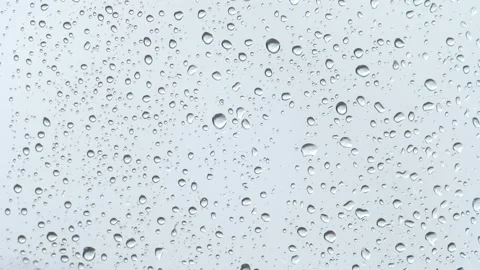 Raindrops flow down the glass on a light background. Video stock 233031957