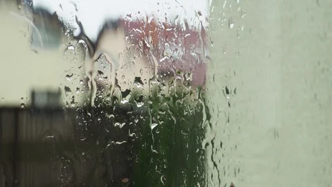 Raindrops flow down the window blurred village houses background Stock Footage 112890271