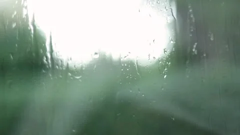 Raindrops Flow Down The Window, Greenery Blurred Background, Close-Up Shot Stock Footage 292302952