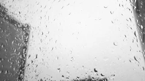 Raindrops flowing down a glass window, a close-up of a colorless black-and-white Stock Footage 318896644