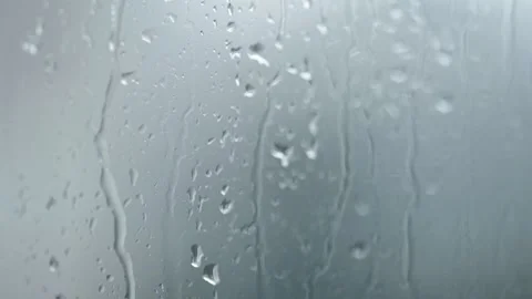 Raindrops flowing down a window glass on a cloudy day. Stock Footage 314834097